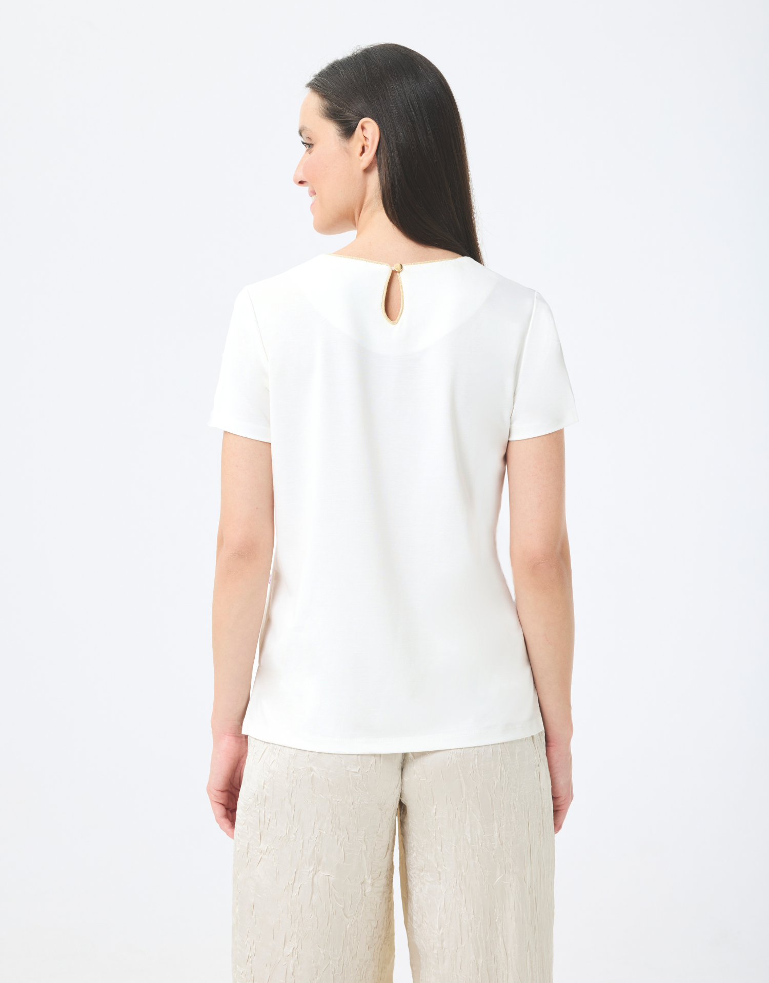 t-shirt col rond écru en coton, manches courtes avec couture dorée autour du col, imprimé bagues colorées, style moderne et audacieux