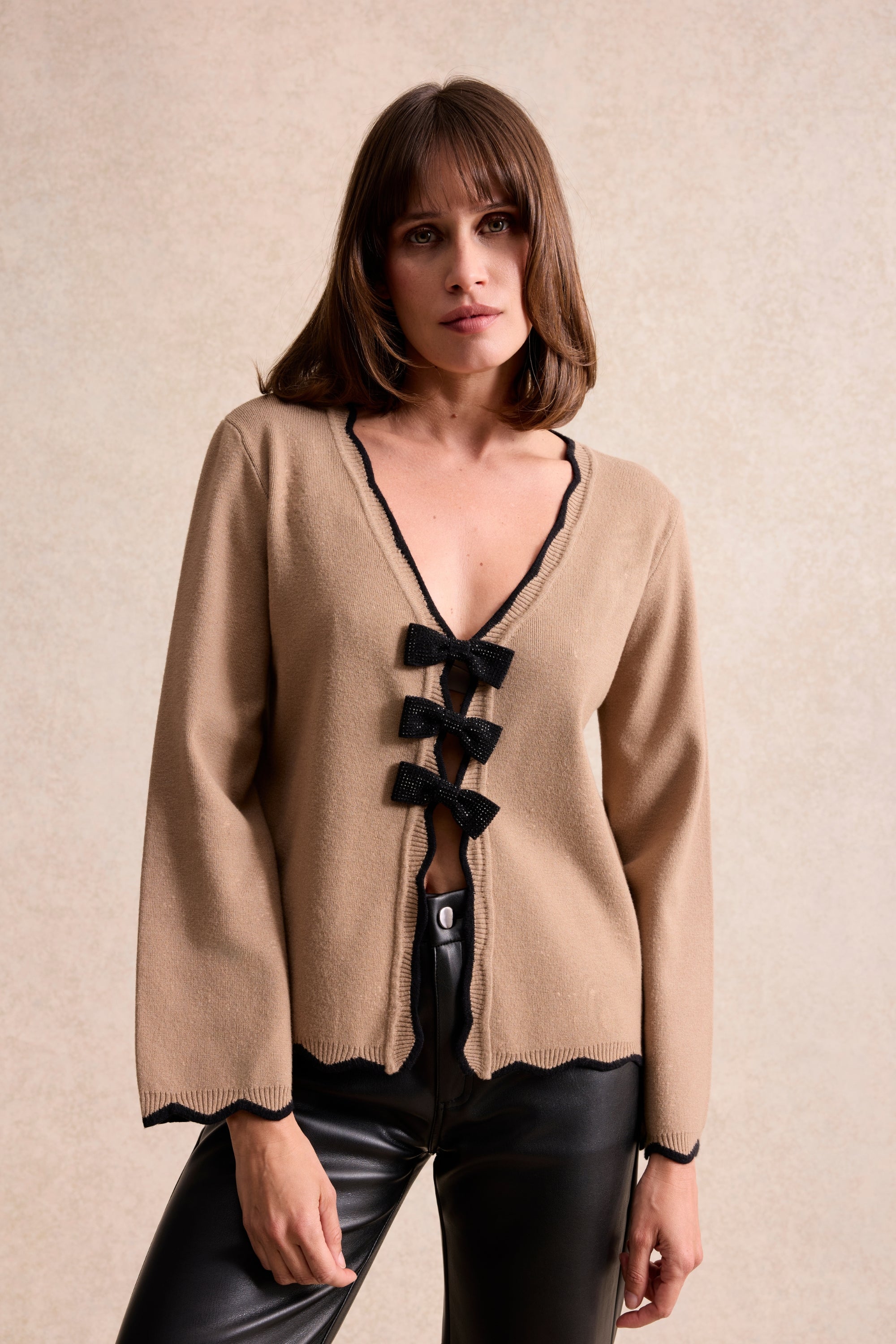 Cardigan beige à nœuds noirs